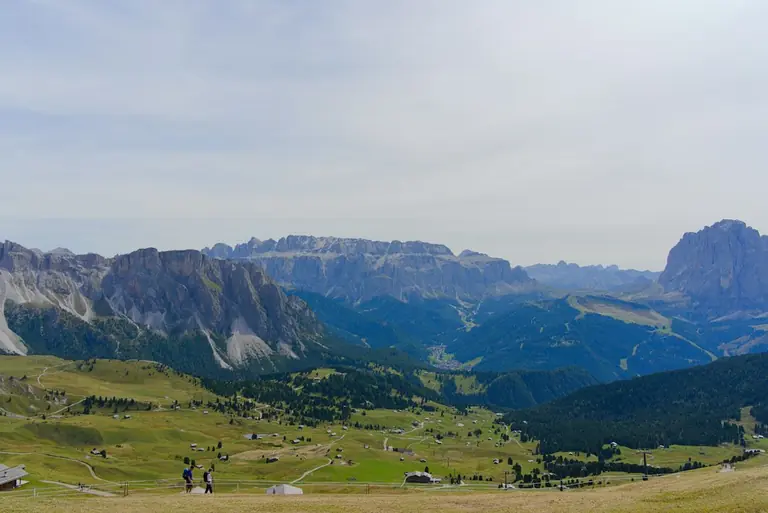 Rolling green hills with distant rocky mountain peaks