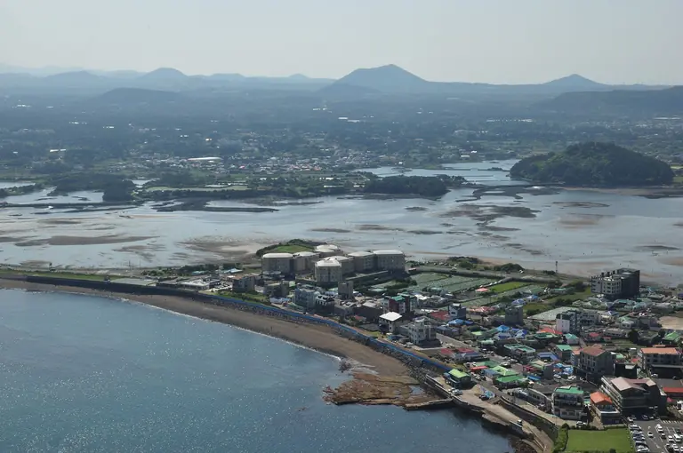 A stunning aerial photo capturing a coastal town in South Korea, with a mix of nature and architecture.