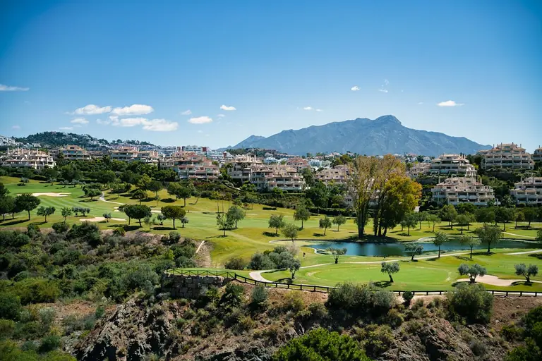 A scenic view of a golf course and mountains