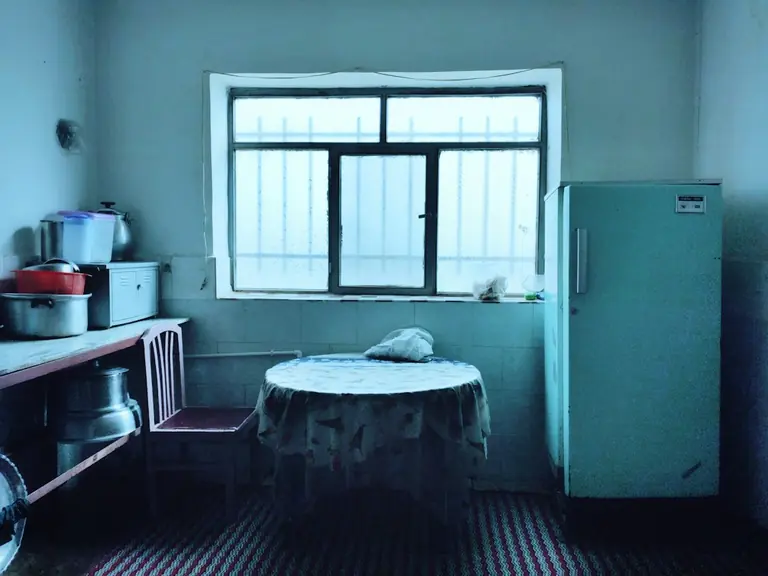 a kitchen with a table and a refrigerator