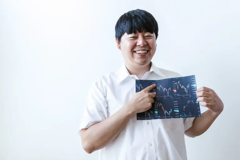 Smiling man presenting cryptocurrency investment chart indoors.