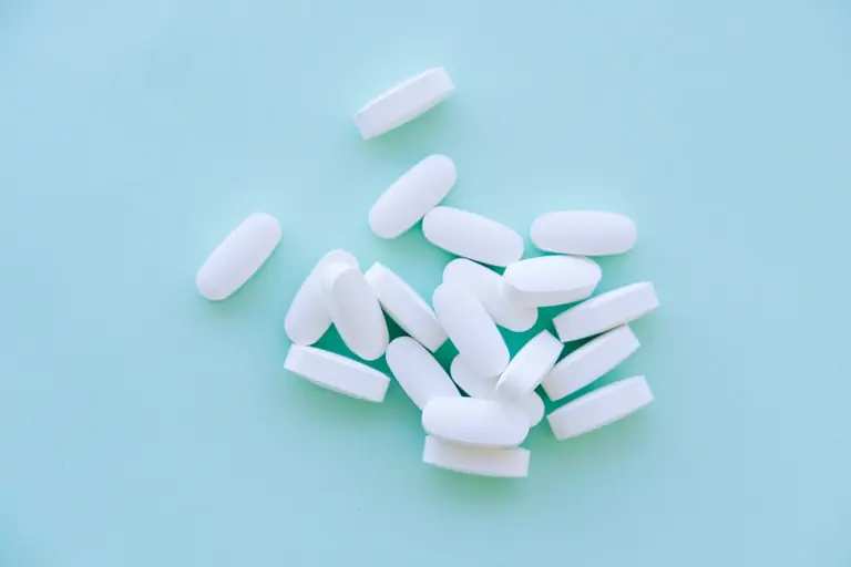 A pile of pills sitting on top of a blue table