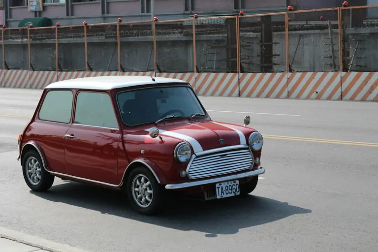 a small red car parked on the side of the road